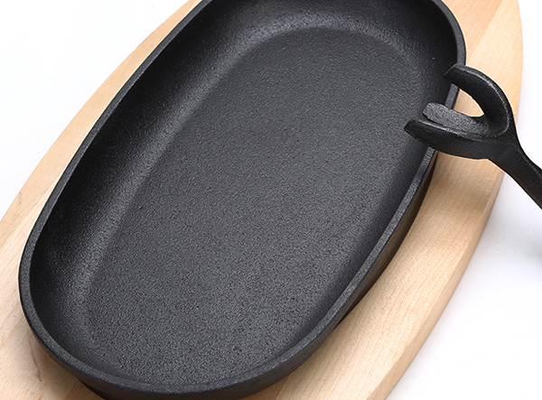 cast iron cookware sizzling plate with wood tray